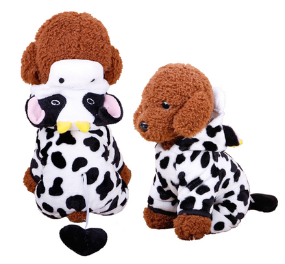 Two plush toys resembling dogs in cow costumes on a white background
